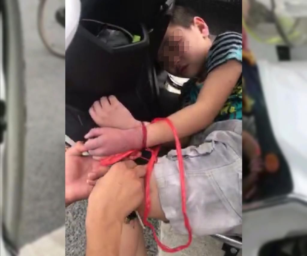  绑住|女子将9岁儿子绑住手脚塞在电动车座下方，孩子手发紫，胳膊出血