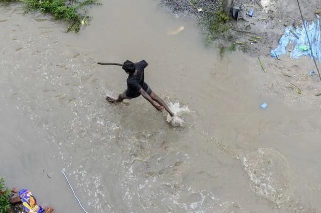 在家|在家躲疫情的印度人，又被暴雨洪水逼进了拥挤的避难所