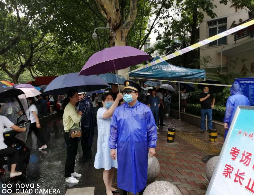 考场|暖心!中考考场外,家长默默地为他撑伞