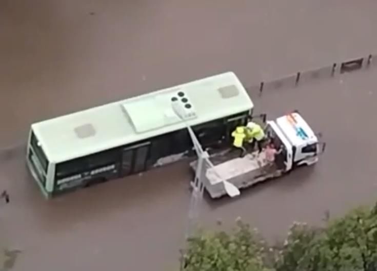 四川自贡暴雨两辆公交车被困积水抛锚，交警巧用拖车转移10余名乘客