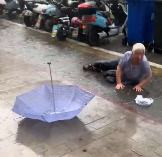 老人在雨中摔倒无法起身，陌生女子上前帮忙：来不及多想，赶紧扶起来