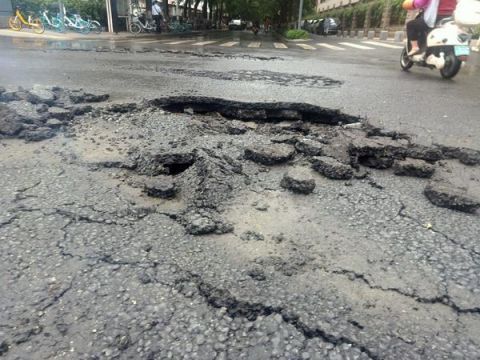  摆放|雨中路面出现三处破损，热心人及时摆放反光锥提醒车辆绕行